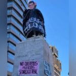 MUJERES CREANDO COLOCA IMAGEN DE RODRIGO PAZ SOBRE ESTATUA DE CRISTÓBAL COLÓN