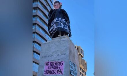 MUJERES CREANDO COLOCA IMAGEN DE RODRIGO PAZ SOBRE ESTATUA DE CRISTÓBAL COLÓN